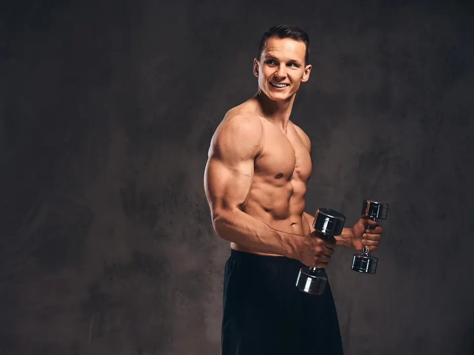 Hombre musculoso sosteniendo un par de mancuernas