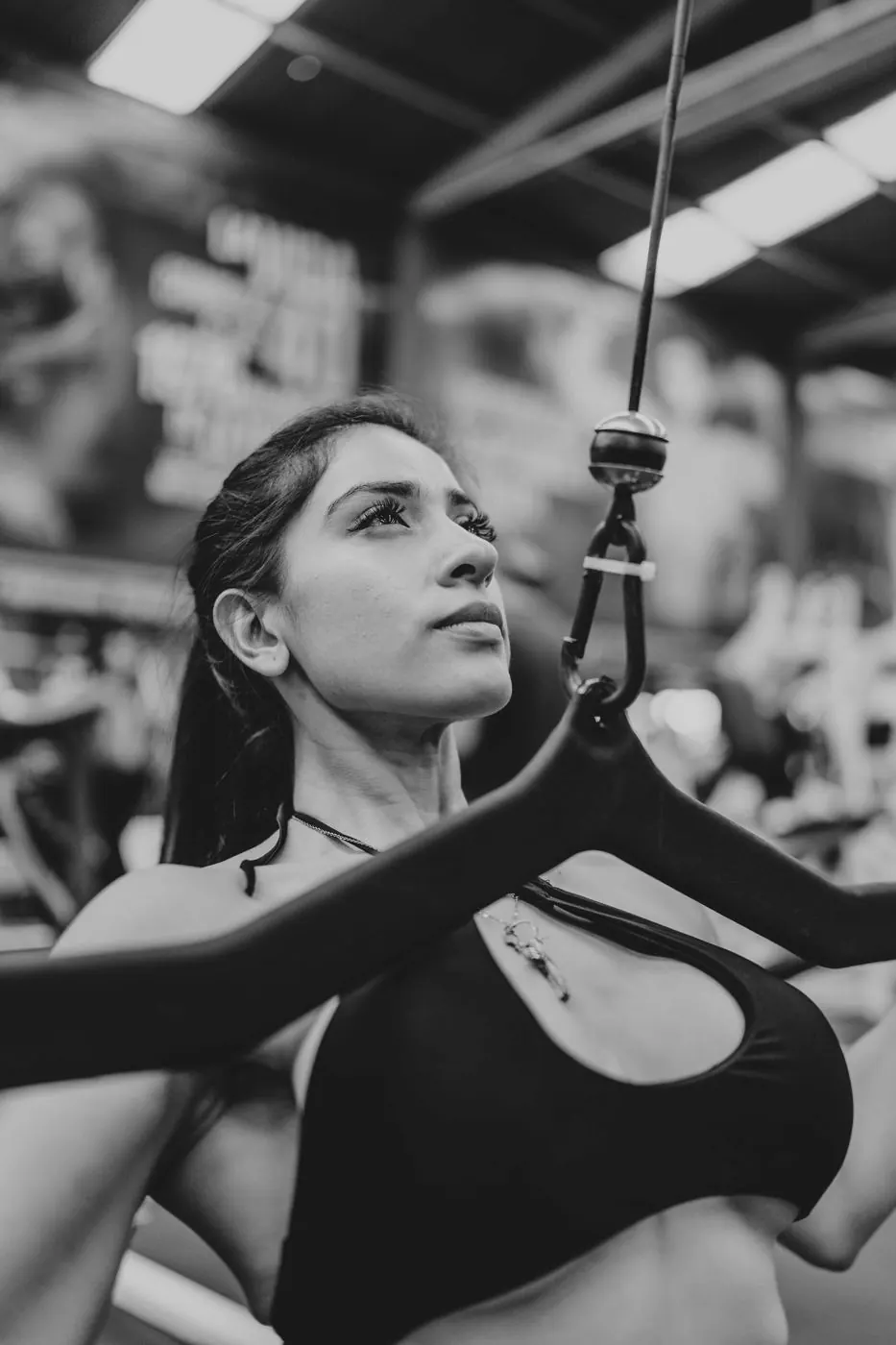 Mujer haciendo jalón en polea, en blanco y negro