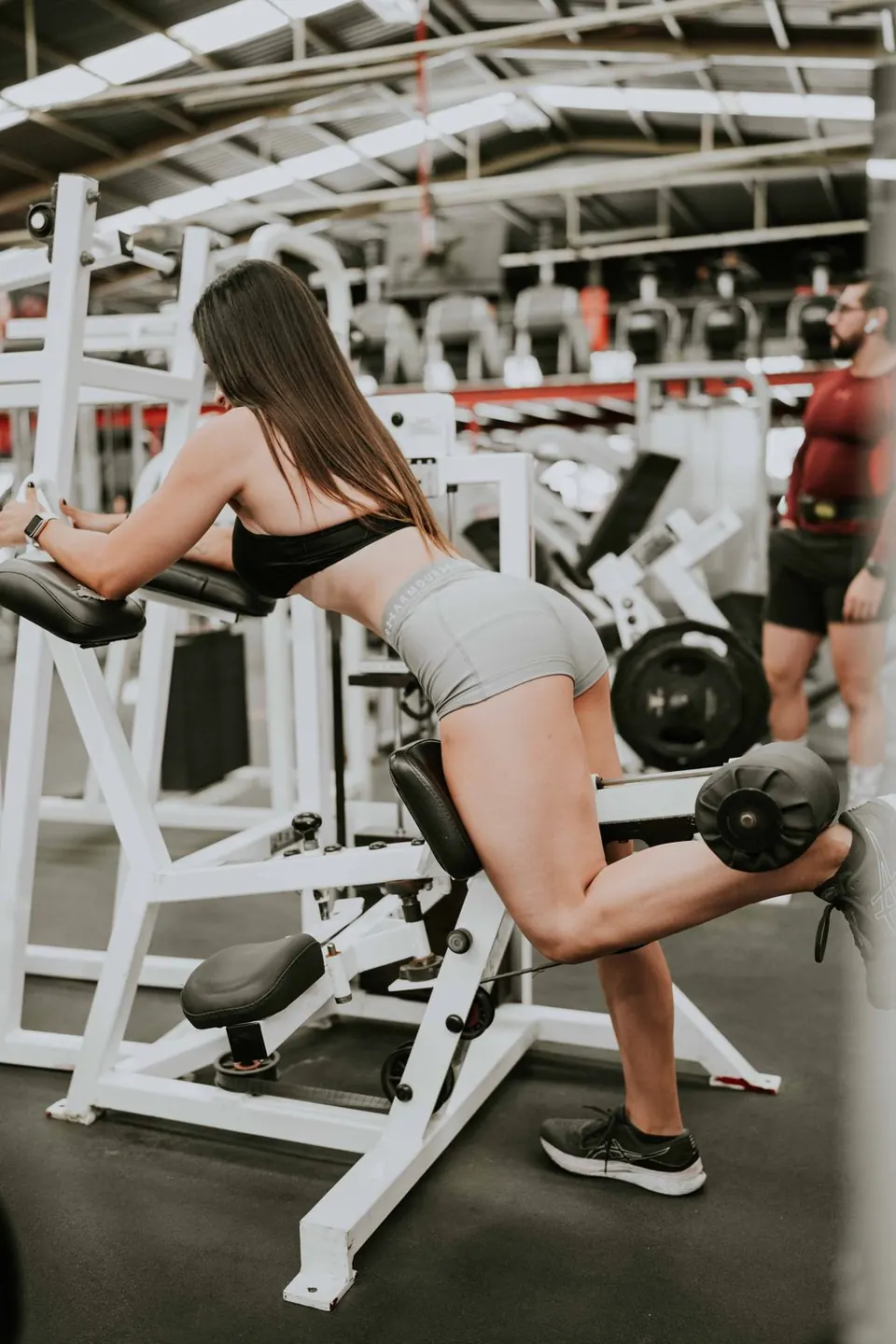 Mujer haciendo patada de glúteo en máquina