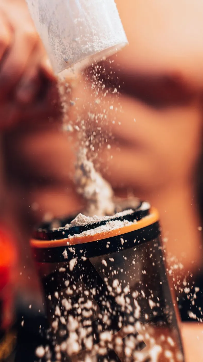 Proteína en polvo cayendo en un vaso